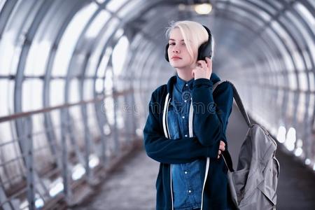 年幼的学生收听的向音乐采用大的耳机采用指已提到的人地铁