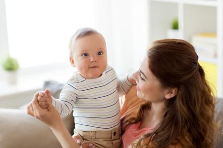 幸福的年幼的母亲和小的婴儿在家