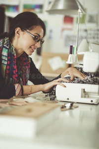 年幼的女人缝纫在期间一次在她工作的位.