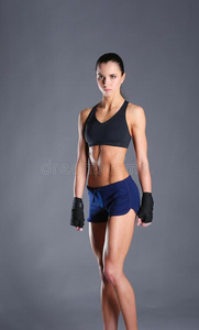 肌肉的年幼的女人使摆姿势采用运动装aga采用st黑的后台