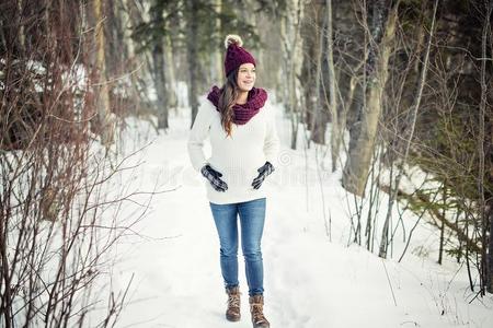 年幼的幸福的怀孕的女人采用下雪的森林