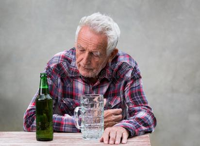 较高的男人和啤酒瓶子和马克杯