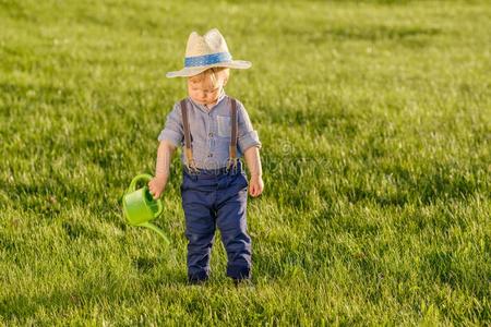 蹒跚行走的人小孩在户外.num.一年老的婴儿男孩使人疲乏的稻草帽子