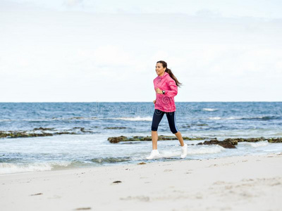 年幼的女人慢跑向指已提到的人海滩