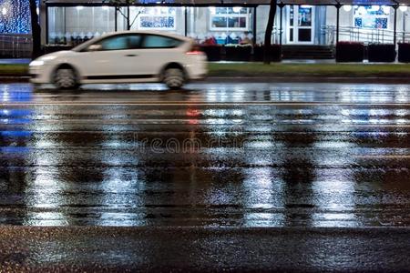 变模糊汽车操纵向湿的路关于城市大街在下雨的夜