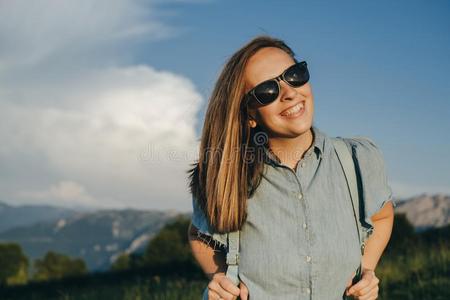 迷人的女人旅行支票和蓝色背包和太阳镜