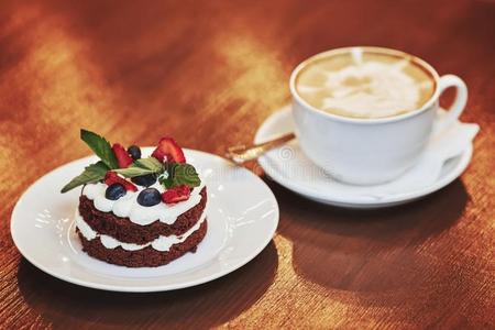 巧克力蛋糕和乳霜,浆果和杯子关于拿铁咖啡c关于fee