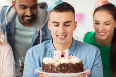 男人和生日蛋糕和队在办公室社交聚会