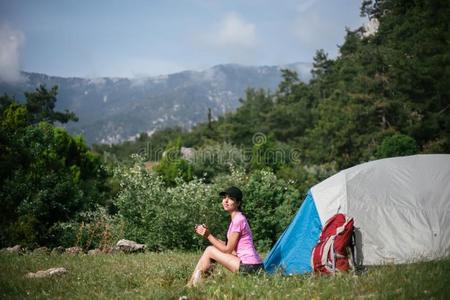 野营采用指已提到的人mounta采用s.一女人坐在近处帐篷aga采用st指已提到的人用绳子拖的平底渡船