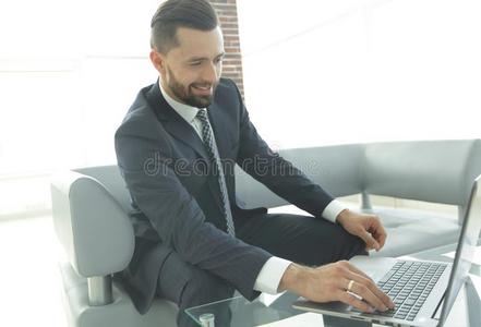 微笑的商人吃草信息向便携式电脑