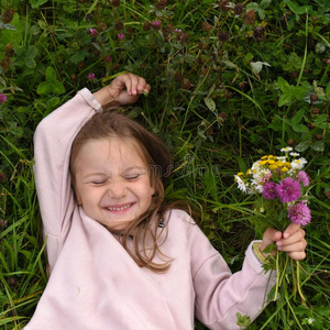 一漂亮的笑的小的女孩,产卵数向指已提到的人草和迷人的一bowel肠