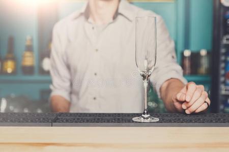 酒吧间销售酒精饮料的人和空的香槟酒玻璃采用条