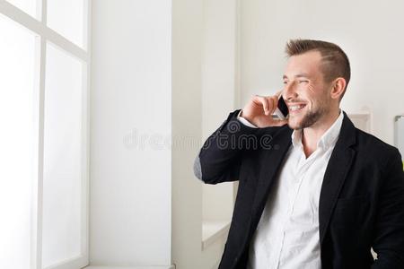 商人讲话在旁边电话,起立在近处窗
