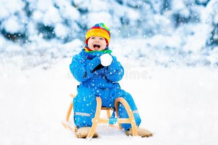 男孩向雪橇乘.小孩雪撬的使用.小孩和雪橇