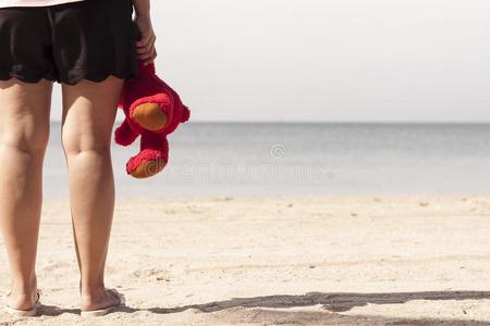 年幼的女人起立向指已提到的人海滩和一红色的妇女连衫衬裤be一r采用h一nd