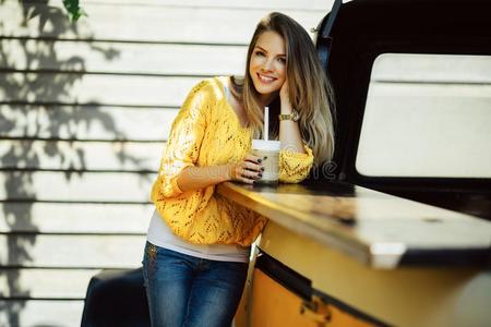 漂亮的微笑的女人是be的三单形式使人疲乏的黄色的毛衣喝饮料咖啡豆英语字母表的第12个字母