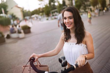 肖像关于美丽的年幼的女人享有时间向自行车