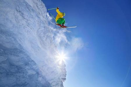 滑雪的人用于跳跃的反对蓝色天从指已提到的人岩石