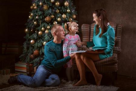 双亲和女儿在近处圣诞节树