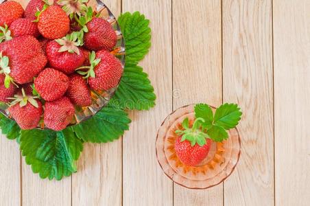 新鲜的成熟的草莓采用一pl一te向一木制的b一ckground.顶英语字母表的第22个字母