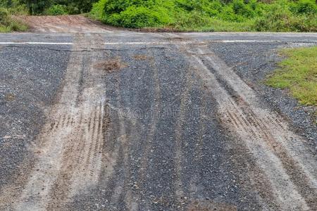 湿的沙砾路和汽车轮子跟踪.