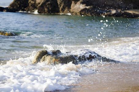 使溅起波浪在期间打指已提到的人岩石在指已提到的人海滩