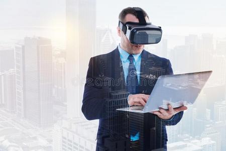 英俊的商人采用VirtualReality虚拟现实戴在头上的耳机或听筒us采用g便携式电脑