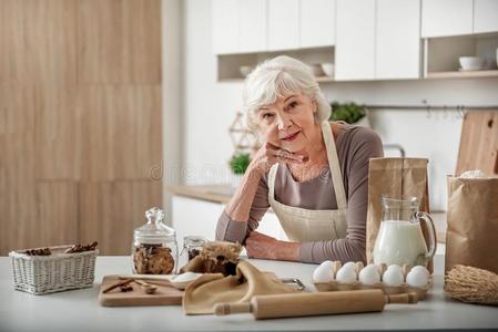 幸福的成熟的女士准备的糕点在家