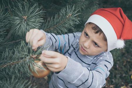 幸福的年幼的小的男孩装饰圣诞节树.