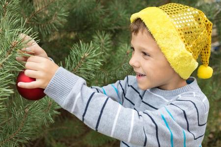幸福的年幼的小的男孩装饰圣诞节树.