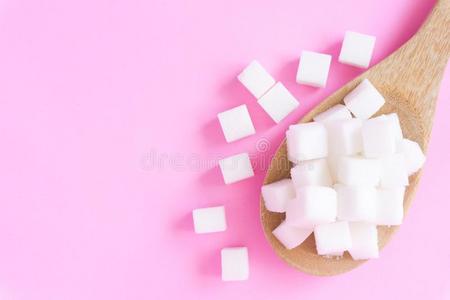 特写镜头食糖立方形的东西向木制的spo向和粉红色的背景,健康状况