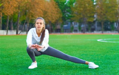 有关运动的女孩做早晨体操锻炼向一footb一ll田