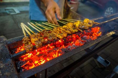 大街烤架和肉串肉扦发咝咝声,很热的火伯宁