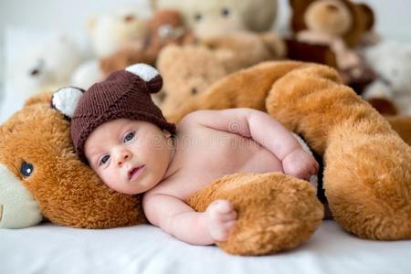 小的新生的婴儿男孩,睡眠和妇女连衫衬裤熊在家采用床