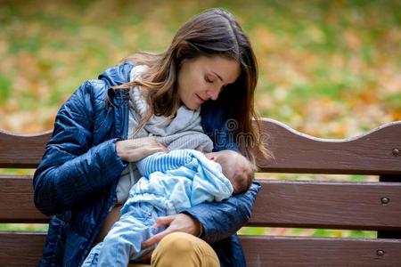 年幼的母亲,用母乳喂养她新生的婴儿男孩户外的采用指已提到的人