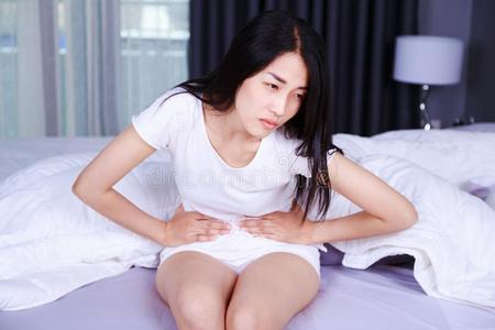女人和胃疼痛向床采用床room