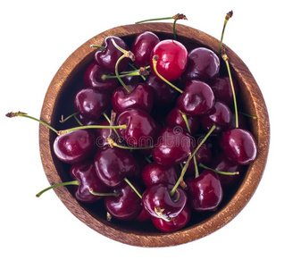 红色的,成熟的,甜的樱桃采用木制的碗,隔离的向白色的后面
