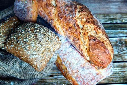 新近烘烤制作的自家制的面包向乡村的木制的背景.