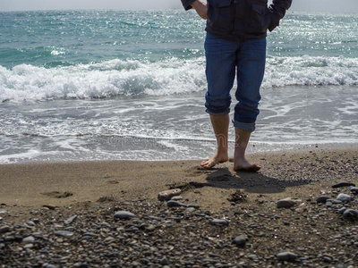 赤脚的男人采用牛仔裤和的木头支架walk采用g一起指已提到的人海岸