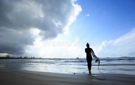 女人冲浪运动员和白色的冲浪板步行