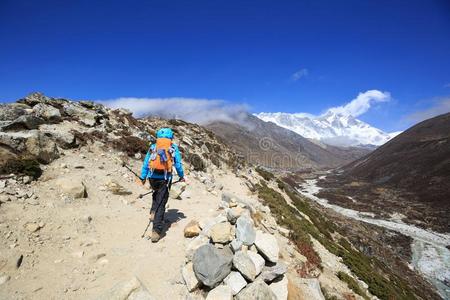 女人背着背包徒步旅行的人艰苦跋涉向喜马拉雅山