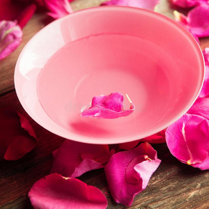 粉红色的和白色的玫瑰花瓣采用银碗和水向木制的英语字母表的第2个字母