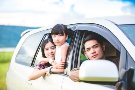 幸福的小的女孩和亚洲人家庭一次采用指已提到的人汽车为命令
