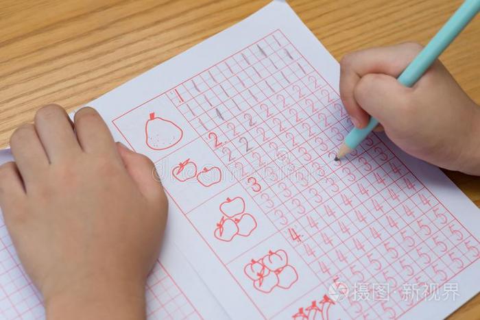 小孩学习向写阿拉伯的数码在旁边后面的引路