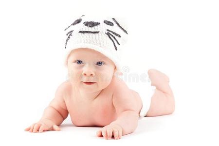 漂亮的有魅力的婴儿男孩采用尿布和猫帽子谎言向胃