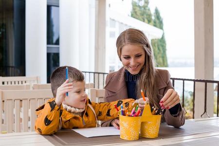 妈妈和年幼的男孩绘画有色的铅笔