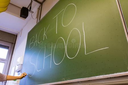 女性的手教师文字向绿色的黑板教授大学