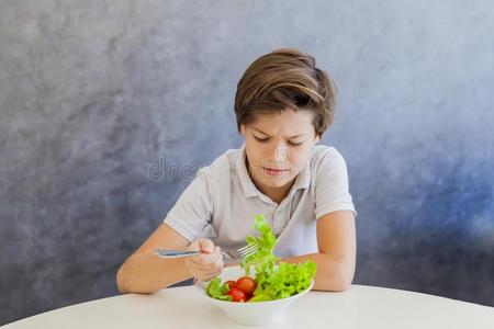 漂亮的青少年男孩吃沙拉