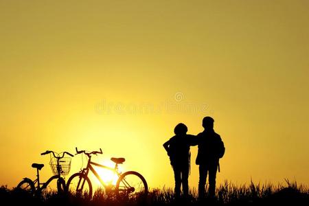 小的男孩和女孩骑马自行车在日落,积极的小孩运动,一
