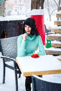 有魅力的年幼的女孩饮料一咖啡采用大街c一fe一t下雪的winter冬天